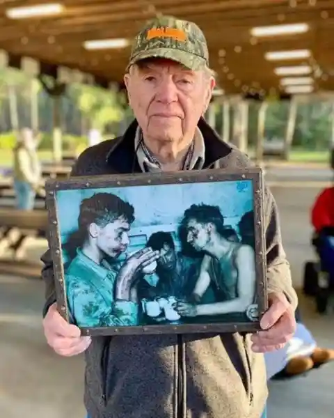 Faris Tuohy, who fought in WWII, is holding a photo from 1944. That’s him on the left, holding a cup of coffee, after one of many hellacious battles. He will be 95 this April.&nbsp;
