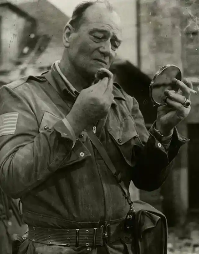 John Wayne without his toupee and touching up makeup during the filming of The Longest Day 1961.
