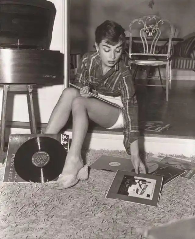 Audrey Hepburn listening to records in her Manhattan apartment, 1954.